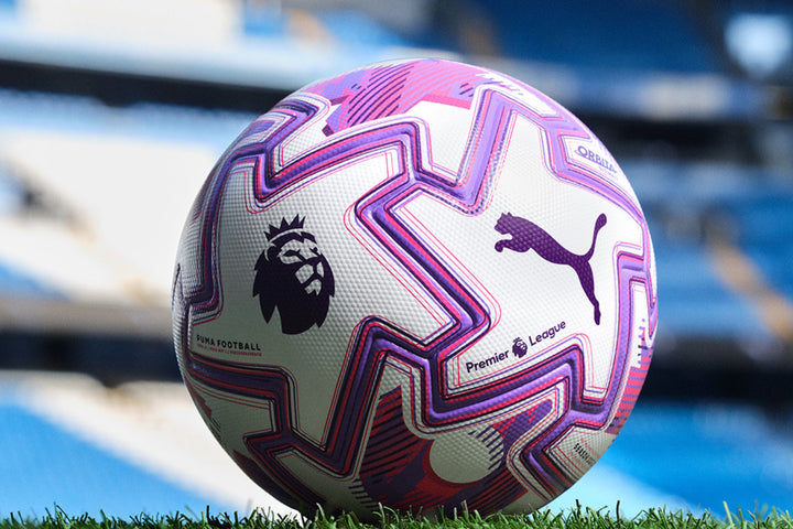 Ballon officiel Puma de la Premier League posé sur un terrain de football dans un stade.