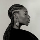 Femme avec tresses africaines plaquées et coiffure protectrice en portrait de profil noir et blanc.