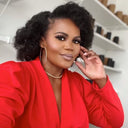 Femme avec maquillage professionnel et coiffure bouclée dans un salon de beauté.